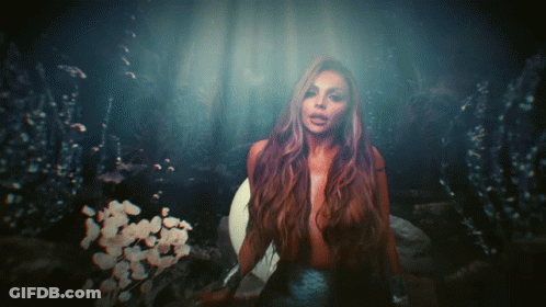 A Woman With Long Hair Is Standing In The Dark GIF