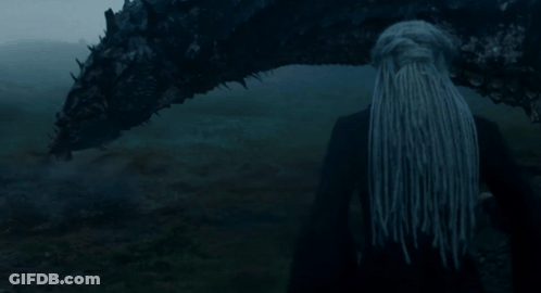 A Woman With Long Hair Is Standing Next To A Large Dragon GIF