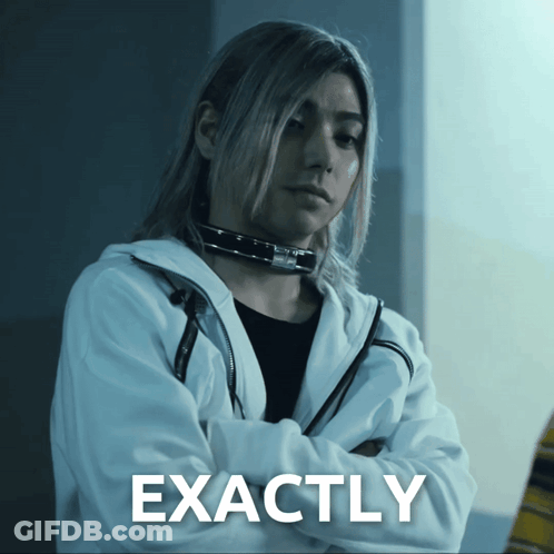 A Woman With Long Hair Is Standing With Her Arms Crossed In Front Of A Sign That Reads Exactly GIF