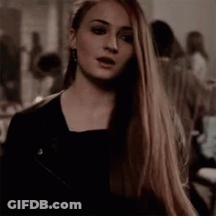 A Woman With Long Hair Is Wearing A Black Jacket And Earrings . GIF