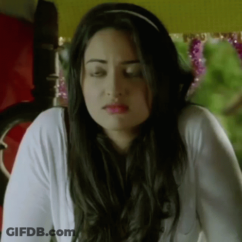 A Woman With Long Hair Is Wearing A Headband And A White Shirt . GIF