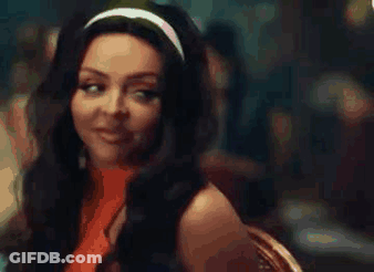 A Woman With Long Hair Is Wearing A Headband And Smiling While Sitting At A Table . GIF