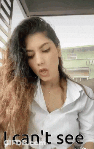 A Woman With Long Hair Is Wearing A White Shirt And Says I Can T See GIF