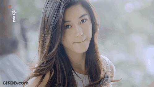 A Woman With Long Hair Looks At The Camera With A Foreign Language Written On The Bottom Right Corner GIF