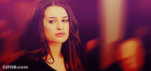 A Woman With Long Hair Looks At The Camera With A Purple Background GIF
