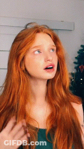 A Woman With Long Red Hair And Blue Eyes Looks Up At Something GIF