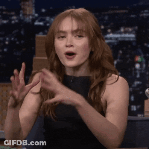 A Woman With Long Red Hair Is Making A Funny Face GIF