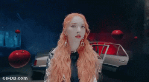 Woman With Long Red Hair In Front Of Silver Car GIF