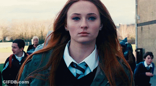 A Woman With Long Red Hair Is Wearing A Tie And A Jacket . GIF
