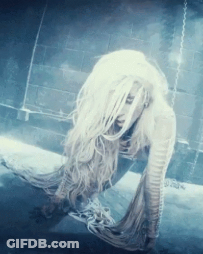 A Woman With Long White Hair Is Laying On The Ground GIF