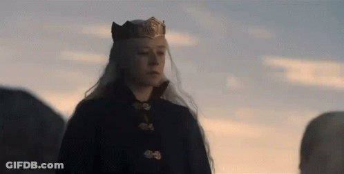 A Woman With Long White Hair Is Wearing A Crown And A Black Coat . GIF