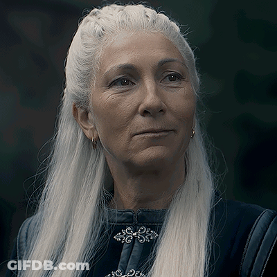 A Woman With Long White Hair Is Wearing Earrings And A Black Jacket GIF