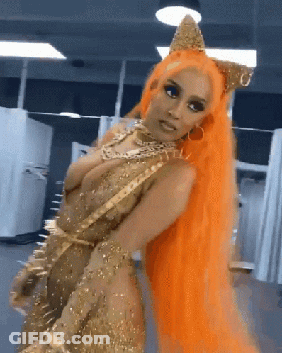 A Woman With Orange Hair Is Wearing A Gold Dress And A Crown GIF