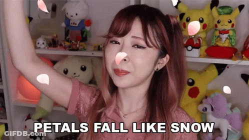 A Woman With Petals Falling On Her Face And The Words Petals Fall Like Snow GIF
