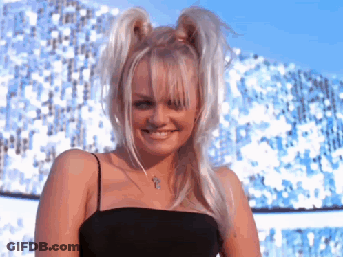 A Woman With Pigtails And A Cross Necklace Is Smiling For The Camera GIF