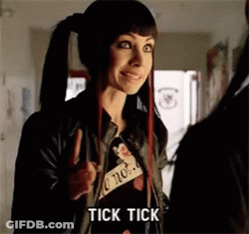 A Woman With Pigtails Is Giving A Peace Sign And The Word Tick Tick Is On The Screen GIF