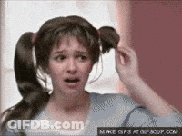 A Woman With Pigtails Is Looking At Her Hair GIF