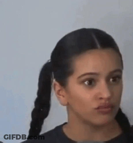 A Woman With Pigtails Is Making A Funny Face And Looking At The Camera . GIF