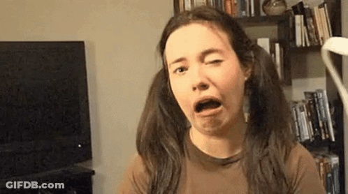 A Woman With Pigtails Is Making A Funny Face While Sitting In Front Of A Television . GIF