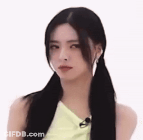 A Woman With Pigtails Is Making A Funny Face While Wearing A Yellow Top . GIF