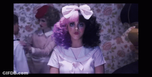 A Woman With Pink And Purple Hair And A White Bow GIF