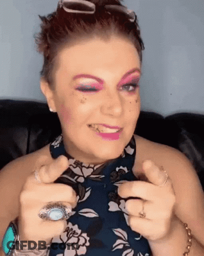 A Woman With Pink Eye Shadow And A Turquoise Ring GIF
