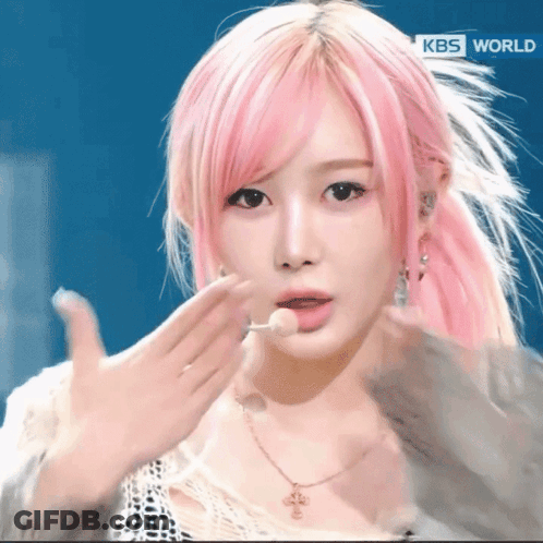 A Woman With Pink Hair And A Kbs World Logo GIF