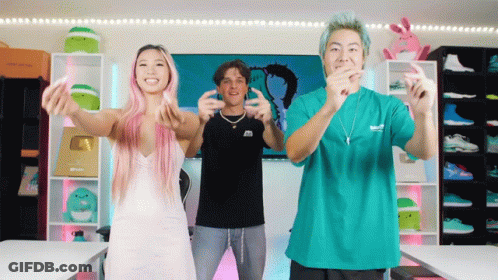A Woman With Pink Hair And A Man In A Green Shirt Are Dancing GIF
