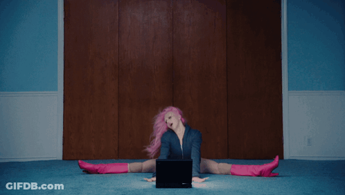 A Woman With Pink Hair And Blue Shorts Is Laying On The Floor GIF