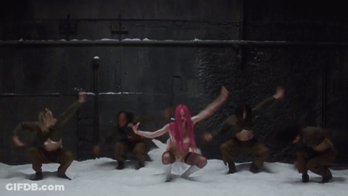 A Woman With Pink Hair Is Dancing In Front Of A Group Of Dancers GIF