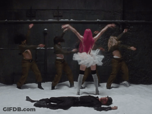 A Woman With Pink Hair Is Dancing In Front Of A Group Of Soldiers GIF