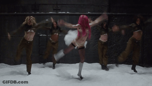 A Woman With Pink Hair Is Dancing In The Snow With Other Women GIF