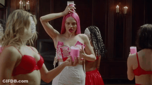 A Woman With Pink Hair Is Holding A Candle In Her Hand GIF