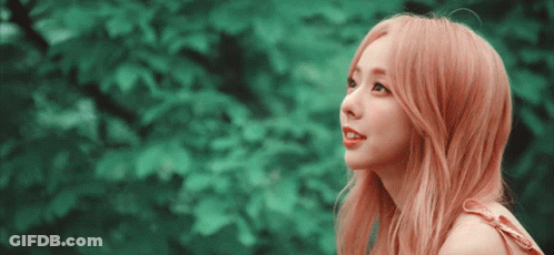 A Woman With Pink Hair Is Looking Up At The Sky GIF