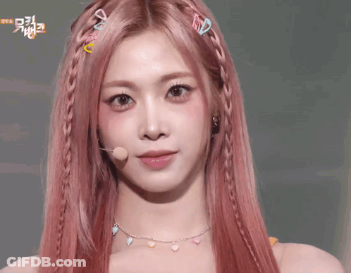 A Woman With Pink Hair Is Making A Face With Her Hands On Her Face . GIF