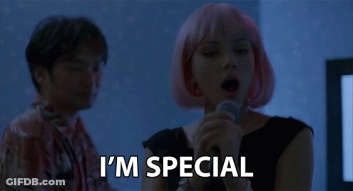 A Woman With Pink Hair Is Singing Into A Microphone And The Words I 'M Special Are Below Her GIF
