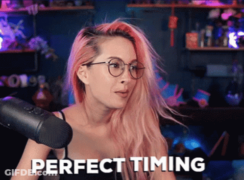 A Woman With Pink Hair Is Sitting In Front Of A Microphone And Says Perfect Timing . GIF
