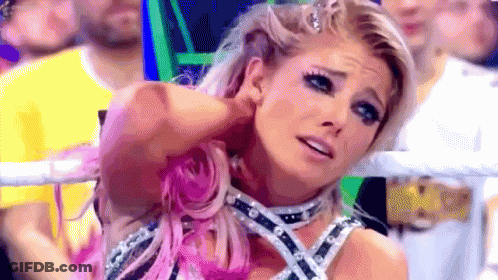 A Woman With Pink Hair Is Standing In A Ring With A Crowd Behind Her . GIF