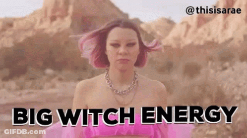 A Woman With Pink Hair Is Standing In The Desert With The Words `` Big Witch Energy '' . GIF