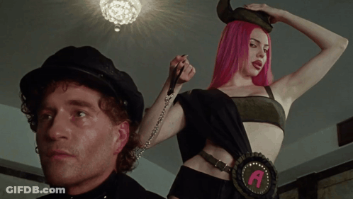 A Woman With Pink Hair Is Wearing A Belt With The Letter A GIF