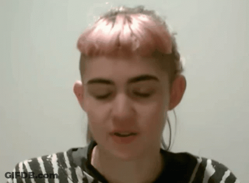 A Woman With Pink Hair Is Wearing A Black And White Shirt GIF