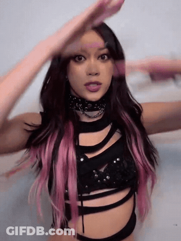 A Woman With Pink Hair Is Wearing A Black Top And Choker GIF
