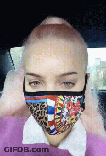 A Woman With Pink Hair Is Wearing A Mask GIF