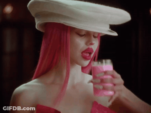 A Woman With Pink Hair Is Wearing A White Hat And Holding A Pink Drink . GIF