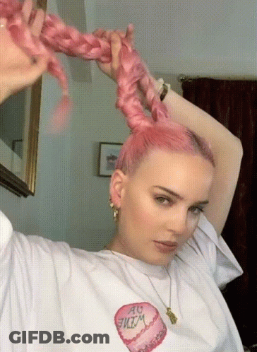 A Woman With Pink Hair Is Wearing A White T-Shirt That Has A Heart On It GIF