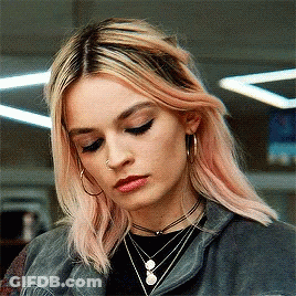 A Woman With Pink Hair Is Wearing Hoop Earrings And A Choker Necklace GIF