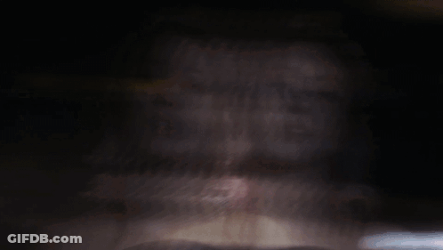 A Woman With Pink Hair Looks At The Camera GIF