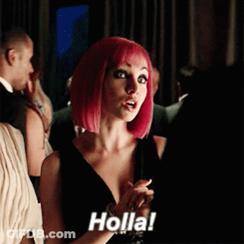 A Woman With Pink Hair Says Holla In A Crowded Room GIF