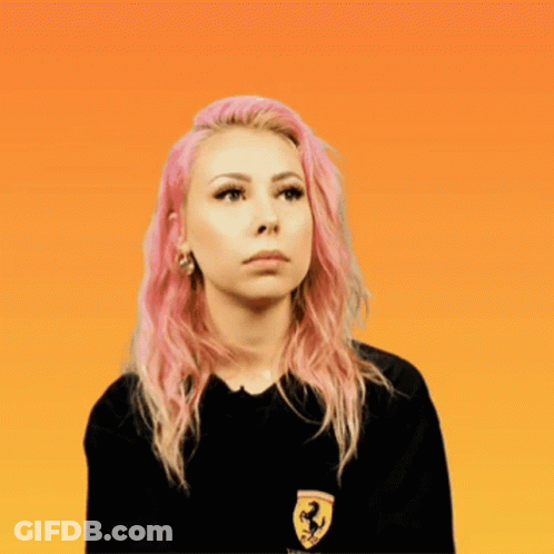A Woman With Pink Hair Wears A Black Shirt With A Ferrari Logo On It GIF