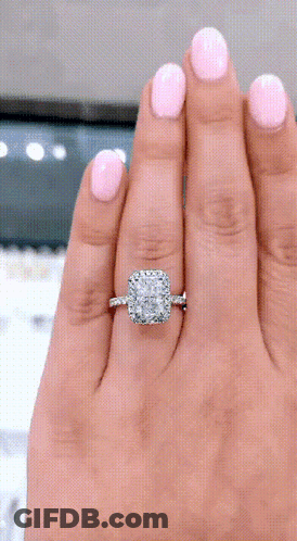 A Woman With Pink Nails Is Wearing A Diamond Ring On Her Left Hand GIF